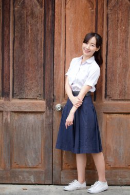 Taylandlı liseli üniformasının portresi. Genç güzel kız mutlu ve rahat.