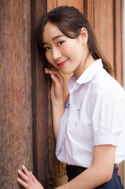 Taylandlı liseli üniformasının portresi. Genç güzel kız mutlu ve rahat.