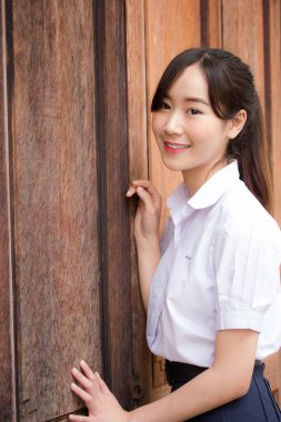 Taylandlı liseli üniformasının portresi. Genç güzel kız mutlu ve rahat.