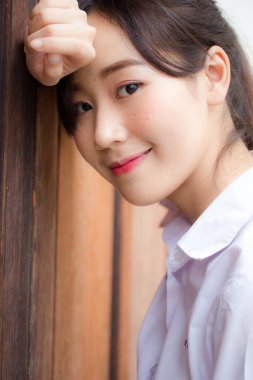 Taylandlı liseli üniformasının portresi. Genç güzel kız mutlu ve rahat.