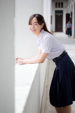 Taylandlı liseli üniformasının portresi. Genç güzel kız mutlu ve rahat.