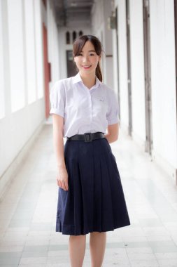 Taylandlı liseli üniformasının portresi. Genç güzel kız mutlu ve rahat.