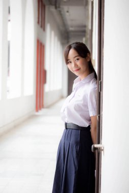 Taylandlı liseli üniformasının portresi. Genç güzel kız mutlu ve rahat.