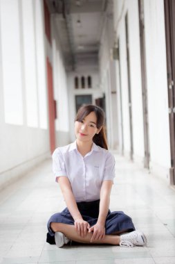 Taylandlı liseli üniformasının portresi. Genç güzel kız mutlu ve rahat.