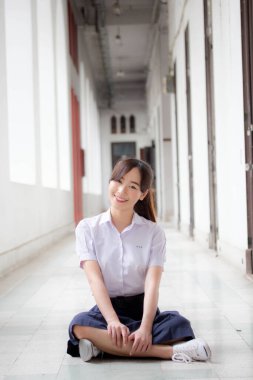 Taylandlı liseli üniformasının portresi. Genç güzel kız mutlu ve rahat.