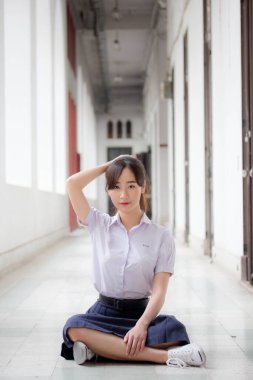 Taylandlı liseli üniformasının portresi. Genç güzel kız mutlu ve rahat.