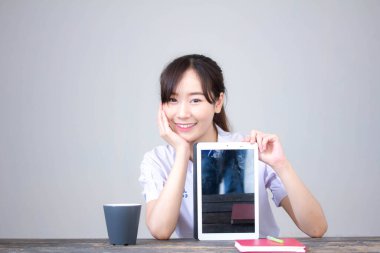 Portrait of thai high school student uniform beautiful girl using her tablet
