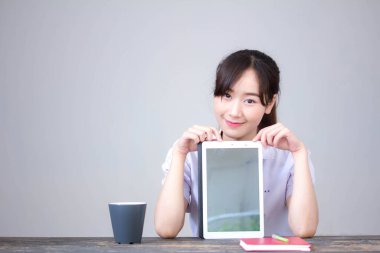 Portrait of thai high school student uniform beautiful girl using her tablet