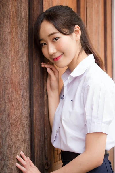 Taylandlı liseli üniformasının portresi. Genç güzel kız mutlu ve rahat.