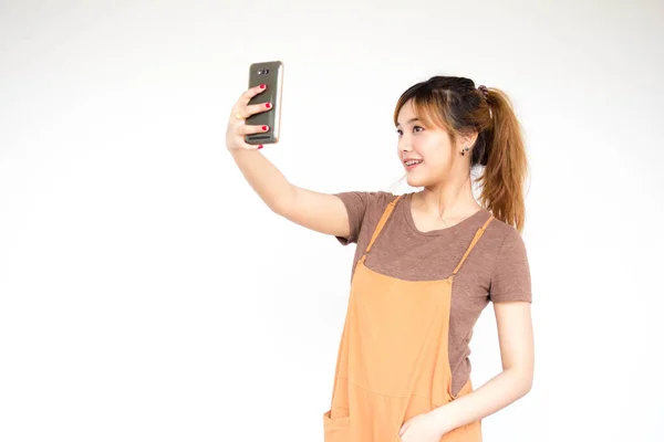 Όμορφη Νεαρή Ενήλικη Ταϊλανδέζα Μπρούτζινα Μαλλιά Χρησιμοποιώντας Έξυπνο Τηλέφωνό Της — Φωτογραφία Αρχείου