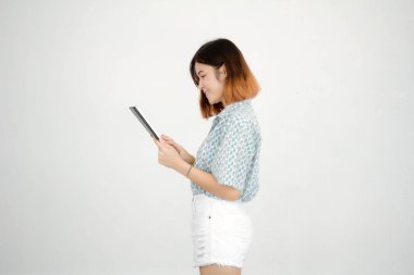 Taylandlı yetişkin güzel kızın tabletini kullanan kısa saçlı portresi..