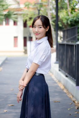 Taylandlı liseli üniformasının portresi. Genç güzel kız mutlu ve rahat.