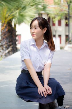 Taylandlı liseli üniformasının portresi. Genç güzel kız mutlu ve rahat.