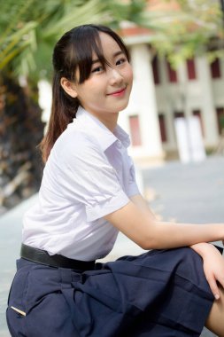 Taylandlı liseli üniformasının portresi. Genç güzel kız mutlu ve rahat.