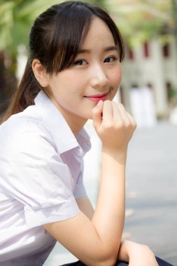 Taylandlı liseli üniformasının portresi. Genç güzel kız mutlu ve rahat.