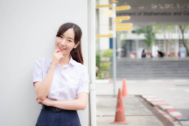 Taylandlı liseli üniformasının portresi. Genç güzel kız mutlu ve rahat.