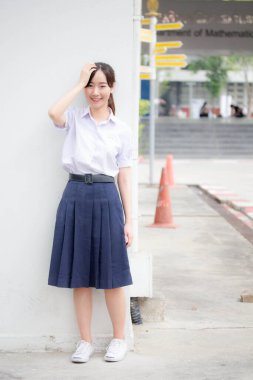 Taylandlı liseli üniformasının portresi. Genç güzel kız mutlu ve rahat.