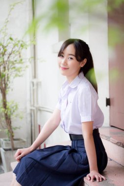 Taylandlı liseli üniformasının portresi. Genç güzel kız mutlu ve rahat.