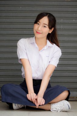 Taylandlı liseli üniformasının portresi. Genç güzel kız mutlu ve rahat.