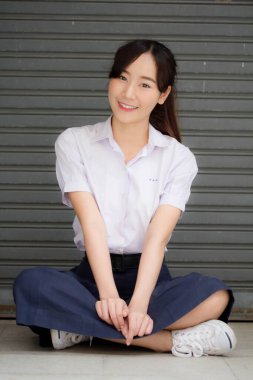 Taylandlı liseli üniformasının portresi. Genç güzel kız mutlu ve rahat.