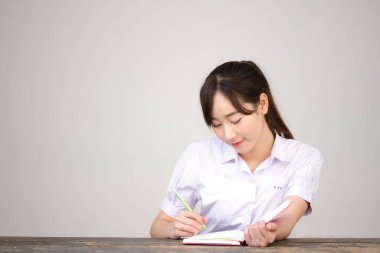 Asya Thai Lisesi üniformalı güzel kız. Bir kitap yaz.