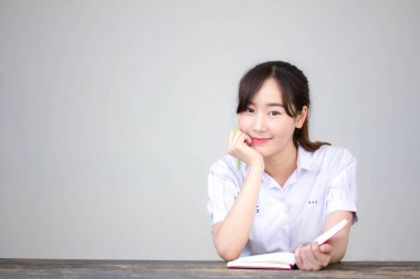 Asya Thai Lisesi üniformalı güzel kız. Bir kitap yaz.