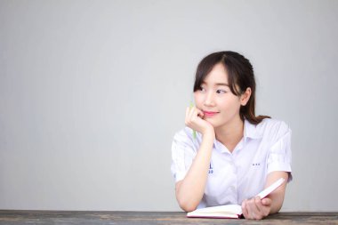 Asya Thai Lisesi üniformalı güzel kız. Bir kitap yaz.