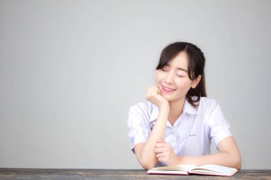 Asya Thai Lisesi üniformalı güzel kız. Bir kitap yaz.