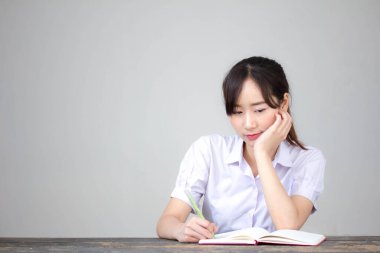 Asya Thai Lisesi üniformalı güzel kız. Bir kitap yaz.