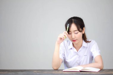 Asya Thai Lisesi üniformalı güzel kız. Bir kitap yaz.