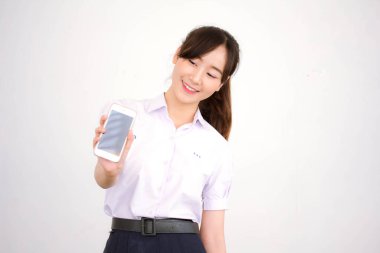 Taylandlı liseli üniformasının portresi. Genç güzel kız akıllı telefon gösteriyor.