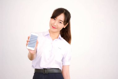 Taylandlı liseli üniformasının portresi. Genç güzel kız akıllı telefon gösteriyor.