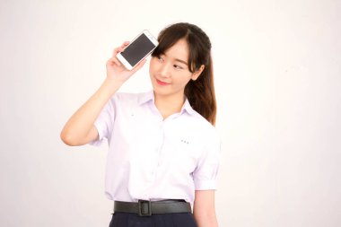 Taylandlı liseli üniformasının portresi. Genç güzel kız akıllı telefon gösteriyor.