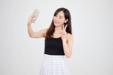Taylandlı yetişkin güzel bir kızın portresi akıllı telefonuyla selfie çekiyor.