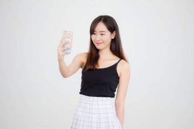 Taylandlı yetişkin güzel bir kızın portresi akıllı telefonuyla selfie çekiyor.