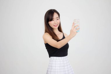 Taylandlı yetişkin güzel bir kızın portresi akıllı telefonuyla selfie çekiyor.
