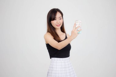 Taylandlı yetişkin güzel bir kızın portresi akıllı telefonuyla selfie çekiyor.