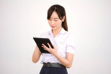 Portrait of thai high school student uniform beautiful girl using her tablet