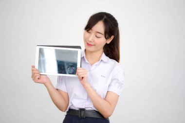Portrait of thai high school student uniform beautiful girl using her tablet