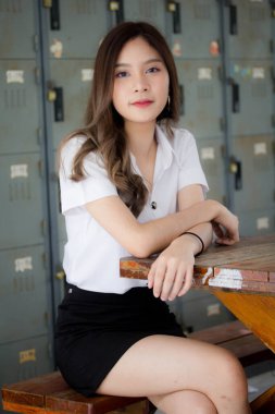 Taylandlı yetişkin öğrenci üniforması portresi. Güzel kız rahatla ve gülümse.