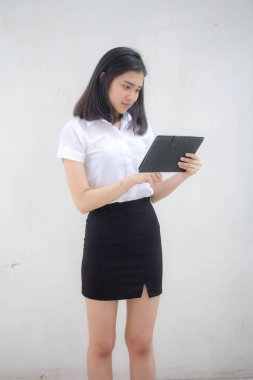 Taylandlı yetişkin öğrenci üniforması tabletini kullanan güzel bir kızın portresi..