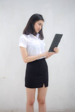 Taylandlı yetişkin öğrenci üniforması tabletini kullanan güzel bir kızın portresi..