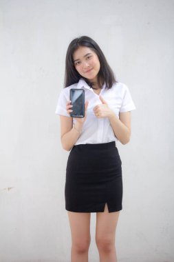 Taylandlı yetişkin öğrenci üniforması portresi. Güzel kız akıllı telefonunu göster.