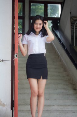 Taylandlı yetişkin öğrenci üniforması portresi. Güzel kız rahatla ve gülümse.