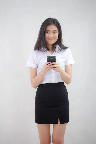 彼女のスマートフォンを使用してタイの大人学生の大学制服美少女の肖像画 — ストック写真