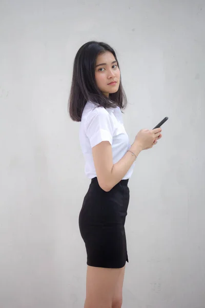 彼女のスマートフォンを使用してタイの大人学生の大学制服美少女の肖像画 — ストック写真
