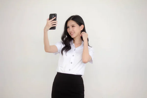 タイのポートレート大人学生大学制服美しいです女の子使用して彼女のスマートフォンSelfie — ストック写真