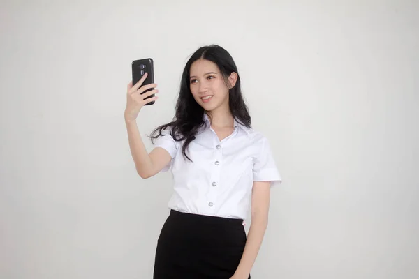 タイのポートレート大人学生大学制服美しいです女の子使用して彼女のスマートフォンSelfie — ストック写真