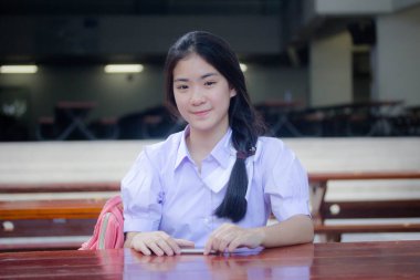 Taylandlı liseli üniformasının portresi. Genç güzel kız mutlu ve rahat.