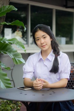 Taylandlı liseli üniformasının portresi. Genç güzel kız mutlu ve rahat.